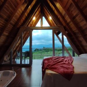 a room with a bed and a large window at ALPINA Zona C cabañas in Socorro