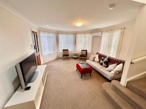 a living room with a couch and a tv at 3 Bedroom Town house near Gosford CBD Sleeps 6 plus in Gosford