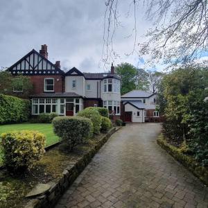 a large house with a driveway in front of it at ChurstonBnB, private flat within family home, Bolton in Lostock