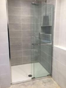 um chuveiro com uma porta de vidro na casa de banho em ChurstonBnB, private flat within family home, Bolton em Lostock