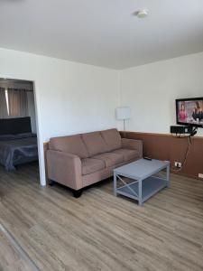 sala de estar con sofá y mesa en Midtown Motel on Alaska Ave, en Dawson Creek