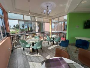 um restaurante com mesas e cadeiras e uma varanda em Primeshare Luxury Apartments for Family Travelers with Swimming Pool, Yaounde em Iaundé