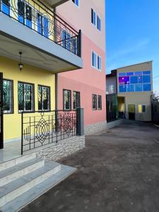 um edifício rosa e amarelo com uma varanda em Primeshare Luxury Apartments for Family Travelers with Swimming Pool, Yaounde em Iaundé