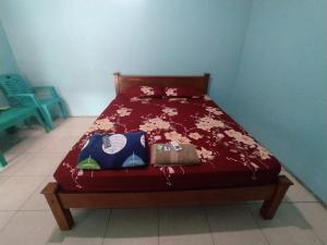 a bed with a red comforter with animals on it at SPOT ON 92537 Tetirah Homestay in Salatiga