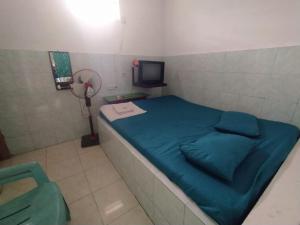 a small room with a bed and a television at SPOT ON 92537 Tetirah Homestay in Salatiga