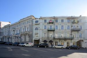 ein großes weißes Gebäude mit davor geparkt in der Unterkunft Vintage Apart on Ekaterininskaya sq. 9 in Odessa