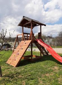 a wooden playset with a slide in a park at Casa Dumitru in Ceraşul