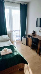 a bedroom with a bed and a desk and a window at Siesta Władysławowo in Władysławowo