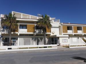 a building with palm trees in front of a street at Aeromar in Faro