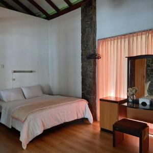 - une chambre avec un lit, un bureau et une fenêtre dans l'établissement Villa Elisabeth at Villa Istana Bunga, à Bandung