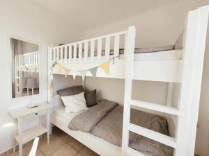 a bedroom with two bunk beds and a desk at Baltrumweg 4 in Wangerland
