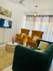 a living room with two chairs and a couch at Lux Suites Hari Apartments Nyali in Mombasa
