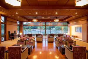 a restaurant with tables and chairs and a large window at Hanayashiki Ukifune-en in Uji