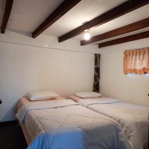 Cette chambre comprend 2 lits dans une chambre dotée de murs blancs et de plafonds en bois. dans l'établissement Villa Elisabeth at Villa Istana Bunga, à Bandung