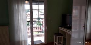 Cette chambre dispose d'une fenêtre donnant sur un balcon. dans l'établissement Toula Apartment, à Litochoro
