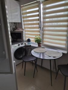 eine Küche mit einem Tisch und einer Waschmaschine in der Unterkunft Viršu street apartaments 5 in Liepāja
