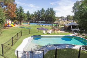 a large swimming pool in a park with a playground at All Seasons Mansfield in Mansfield