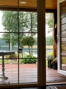 an open door to a patio with a view of the water at Sodyba Paukščių Takas in Aviliai