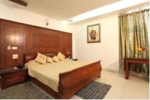 a bedroom with a large bed with a wooden headboard at Hotel Shanta Inn Banquet Hall Top Family Hotels Business Hotels Best Couple Friendly Hotel in Lucknow in Lucknow