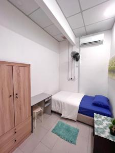 una camera con letto, scrivania, letto e armadio di Just Stay Inn Guest House a Malacca