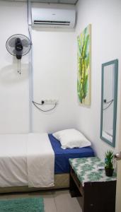 a bedroom with a bed and a mirror and a table at Just Stay Inn Guest House in Malacca