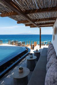 a resort with a swimming pool and the ocean at Almyra Oia Suites in Oia