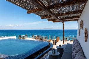 a villa with a swimming pool and a view of the ocean at Almyra Oia Suites in Oia