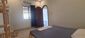 a bedroom with a bed and two windows at Grandma House in Can Tho +42 photos