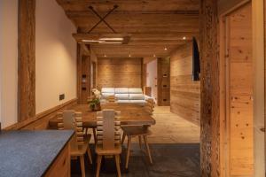 Casa Ca dei Pini في كورتينا دامبيتزو: غرفة طعام مع طاولة وكراسي خشبية