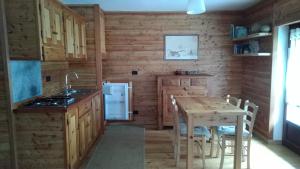 a kitchen with wooden walls and a table with a sink at Casa Pradarèire in Fenestrelle