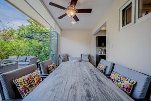 mesa de comedor con sillas y ventilador de techo en Jacarandas, 8 en Tamarindo