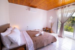 a bedroom with a bed and a large window at Oceanus Summer House in Salamina