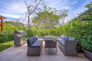 un patio con parrilla, sillas y mesa en Jacarandas, 8 en Tamarindo