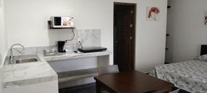 a bathroom with a sink and a table and a bed at Casa Aura - King Suite with Kitchen and Balcony - 1st Floor in Isla Mujeres