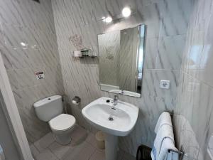 bagno bianco con servizi igienici e lavandino di Hostal Zurich a Sant Feliu de Guíxols