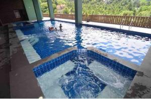 a swimming pool with blue tiles in a house at Carol Crosswinds Tagaytay in Cavite