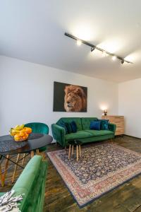uma sala de estar com um sofá verde e um leão na parede em Apartments24 Laada 4 em Rakvere