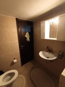 a bathroom with a toilet and a sink at Appartment near centre, bus and train stations in Pyrgos