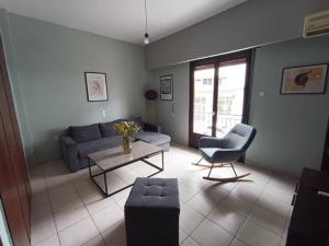 a living room with a couch and a table and a chair at Appartment near centre, bus and train stations in Pyrgos