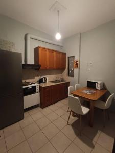 a kitchen with a table and chairs and a kitchen with a stove at Appartment near centre, bus and train stations in Pyrgos