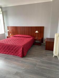 een slaapkamer met een rood bed en 2 nachtkastjes bij Hotel des Sports in Deauville