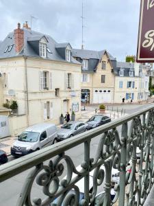 een uitzicht op een straat met geparkeerde auto's en gebouwen bij Hotel des Sports in Deauville