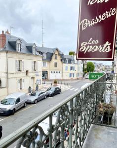 een bord voor een hotel met auto's op straat bij Hotel des Sports in Deauville