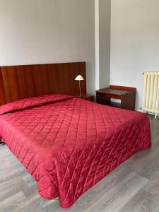 1 cama roja grande con edredón rojo en una habitación en Hotel des Sports, en Deauville