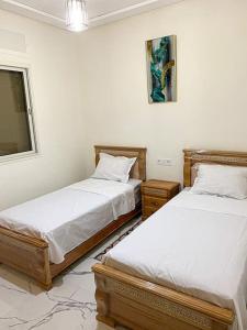 1 Schlafzimmer mit 2 Betten und einem Fenster in der Unterkunft Appartement Familiale Al-Hoceima , Chic & cosy in Al Hoceïma