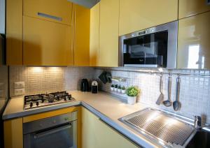 a kitchen with yellow cabinets and a stove and a sink at NonSoloPanorama in Monte San Vito
