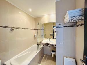 a bathroom with a bath tub and a sink at Les Alizes in Palavas-les-Flots