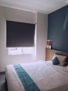 1 dormitorio con cama y ventana grande en The Holiday Guest House, en Tanjung Pandan