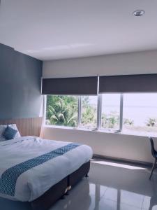 a bedroom with a bed and a large window at The Holiday Guest House in Tanjungpandan