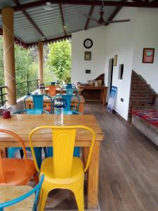 a dining room with wooden tables and yellow chairs at Meraki Living Luxury Homestay, Mukteshwar in Nainital